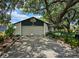 Charming home featuring a driveway and lush landscaping under a mature shady tree at 16134 Ravendale Dr, Tampa, FL 33618
