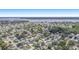Expansive aerial view of a neighborhood with mature trees and a scenic lake in the background at 162 Lagoon Way, Palm Harbor, FL 34684