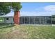 Backyard featuring screened in patio with brick chimney and large grassy area at 162 Lagoon Way, Palm Harbor, FL 34684
