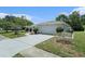 This home features a well-kept lawn, a two-car garage, and a quaint arched entryway with manicured bushes at 162 Lagoon Way, Palm Harbor, FL 34684