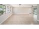 Bright living room with tile floors, large windows, ceiling fan, and sliding doors to the backyard at 162 Lagoon Way, Palm Harbor, FL 34684