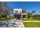 Modern two-story home with a well-manicured lawn, concrete driveway, and a black SUV parked in front at 1625 55Th S St, Gulfport, FL 33707
