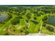 Expansive aerial view of a golf course featuring lush greens, scenic water features, and manicured landscaping at 16317 Colwood Dr, Odessa, FL 33556