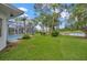 Expansive backyard with a screened pool area, lush lawn, and views of the serene pond at 16317 Colwood Dr, Odessa, FL 33556