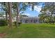 Expansive backyard with large trees and a screened-in pool at 16317 Colwood Dr, Odessa, FL 33556