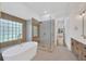 Bright bathroom featuring modern tub, glass enclosed shower with bench, and upscale finishes for a spa-like experience at 16317 Colwood Dr, Odessa, FL 33556