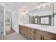 Bright bathroom featuring double vanity, wooden drawers, and expansive mirror, offering a modern and luxurious feel at 16317 Colwood Dr, Odessa, FL 33556