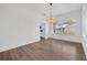 Bright dining room with views of backyard, light wood flooring, and modern hanging light fixture at 16317 Colwood Dr, Odessa, FL 33556