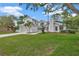Two-story white home featuring a well-manicured lawn, an attached garage and a neatly landscaped front yard at 16317 Colwood Dr, Odessa, FL 33556