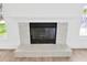 Elegant fireplace with white mantle and decorative tile, flanked by two windows at 16317 Colwood Dr, Odessa, FL 33556