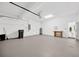 Spacious three-car garage with white walls, workbench, water heater, and plenty of storage space at 16317 Colwood Dr, Odessa, FL 33556