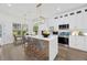Modern kitchen with white cabinetry, stainless steel appliances, and island with seating at 16317 Colwood Dr, Odessa, FL 33556
