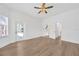 Bright living room features wood floors, modern ceiling fan, and glass doors to the patio at 16317 Colwood Dr, Odessa, FL 33556