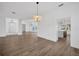 Open-concept living area with view into kitchen, light wood flooring, and modern lighting fixtures at 16317 Colwood Dr, Odessa, FL 33556