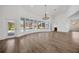 Bright living room with light wood flooring, white walls, and large windows overlooking the outdoor pool area at 16317 Colwood Dr, Odessa, FL 33556