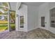Outdoor patio with tiled floor, two doors, and view of backyard, plus a screened-in lanai at 16317 Colwood Dr, Odessa, FL 33556