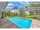 Beautiful screened-in pool with brick patio and lush tropical landscaping in the backyard at 16317 Colwood Dr, Odessa, FL 33556