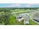 Aerial view showcasing several two-story homes with solar panels and lush green lawns by a highway at 1680 Hazy Sea Dr, Plant City, FL 33565