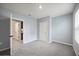 View of a bedroom with gray carpet, leading to a doorway with an ensuite bathroom at 1680 Hazy Sea Dr, Plant City, FL 33565