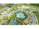 Birds-eye view of community pool surrounded by palm trees, a playground, and sports courts at 1680 Hazy Sea Dr, Plant City, FL 33565