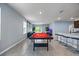 Open-concept game room with a pool table, bar seating, and a cozy living area at 1680 Hazy Sea Dr, Plant City, FL 33565