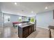 A modern kitchen flows into an open living area with barstool seating at a large island and a pool table in view at 1680 Hazy Sea Dr, Plant City, FL 33565