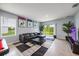 Open living room featuring a black leather sofa, a black rug, and sliding glass doors to the backyard at 1680 Hazy Sea Dr, Plant City, FL 33565