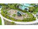 Aerial view of a playground surrounded by palm trees next to a community pool at 1680 Hazy Sea Dr, Plant City, FL 33565