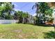 Backyard enclosed by a white fence, adorned with lush tropical landscaping offers a private and tranquil outdoor setting at 1858 Michigan Ne Ave, St Petersburg, FL 33703