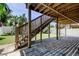 Backyard showcasing a wooden staircase leading to the deck above, with a view of the grass and greenery at 1858 Michigan Ne Ave, St Petersburg, FL 33703
