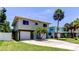 Two-story home featuring a spacious driveway, and complemented by a palm tree at 1858 Michigan Ne Ave, St Petersburg, FL 33703