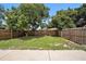 A verdant backyard featuring a privacy fence, mature trees, and lush green grass at 1902 N Tampania Ave, Tampa, FL 33607