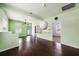 Open living room with wood floors, green walls and lots of light and access to the kitchen at 1902 N Tampania Ave, Tampa, FL 33607