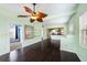 Open living space with a ceiling fan, shelving, and hardwood floors leading to the kitchen at 1902 N Tampania Ave, Tampa, FL 33607