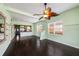 Spacious living room with hardwood floors, a decorative ceiling fan, and views of the kitchen and exterior at 1902 N Tampania Ave, Tampa, FL 33607