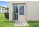 Back entrance featuring a screen door, small garden, and tiled walkway at 19029 Us Highway 19 N # 3-1, Clearwater, FL 33764