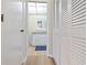 Hallway view of a well-lit bathroom with white cabinets, drawers, and neutral tile at 19029 Us Highway 19 N # 3-1, Clearwater, FL 33764