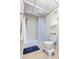 Cozy bathroom features a shower, textured tiles, and a convenient grab bar for added safety at 19029 Us Highway 19 N # 3-1, Clearwater, FL 33764