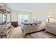 Bright bedroom with a large window, light hardwood floors, and wicker furniture at 19029 Us Highway 19 N # 3-1, Clearwater, FL 33764