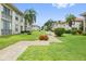 Landscaped exterior showcasing vibrant flowers, lush grass, and a welcoming walkway at 19029 Us Highway 19 N # 3-1, Clearwater, FL 33764