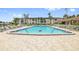 Community pool with lounge chairs and mature palms surrounding the area at 19029 Us Highway 19 N # 3-1, Clearwater, FL 33764