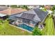 Aerial view of the home featuring a screened-in pool and solar panels at 1958 Marshberry Ct, Trinity, FL 34655