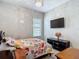 Charming bedroom boasts a mounted TV, chandelier, and a floral patterned bedspread at 1958 Marshberry Ct, Trinity, FL 34655