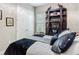 Neutral bedroom with wood-look floors, double door closet, and dark wood shelving unit at 1958 Marshberry Ct, Trinity, FL 34655