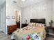 Cozy bedroom with floral bedding, chandelier, and a view of the bathroom at 1958 Marshberry Ct, Trinity, FL 34655