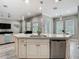 Spacious kitchen island with stainless steel dishwasher, sink, granite countertops and view to living area at 1958 Marshberry Ct, Trinity, FL 34655