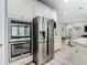 Stainless steel appliances including double ovens and refrigerator are set in this home's modern kitchen at 1958 Marshberry Ct, Trinity, FL 34655