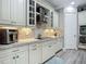 Kitchen with white cabinets, tiled backsplash, stainless appliances, granite countertops, and modern design at 1958 Marshberry Ct, Trinity, FL 34655