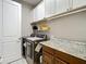 Laundry room with front load washer and dryer and granite countertop at 1958 Marshberry Ct, Trinity, FL 34655