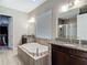 Luxurious bathroom with a garden tub, granite counters, and walk-in closet access at 1958 Marshberry Ct, Trinity, FL 34655